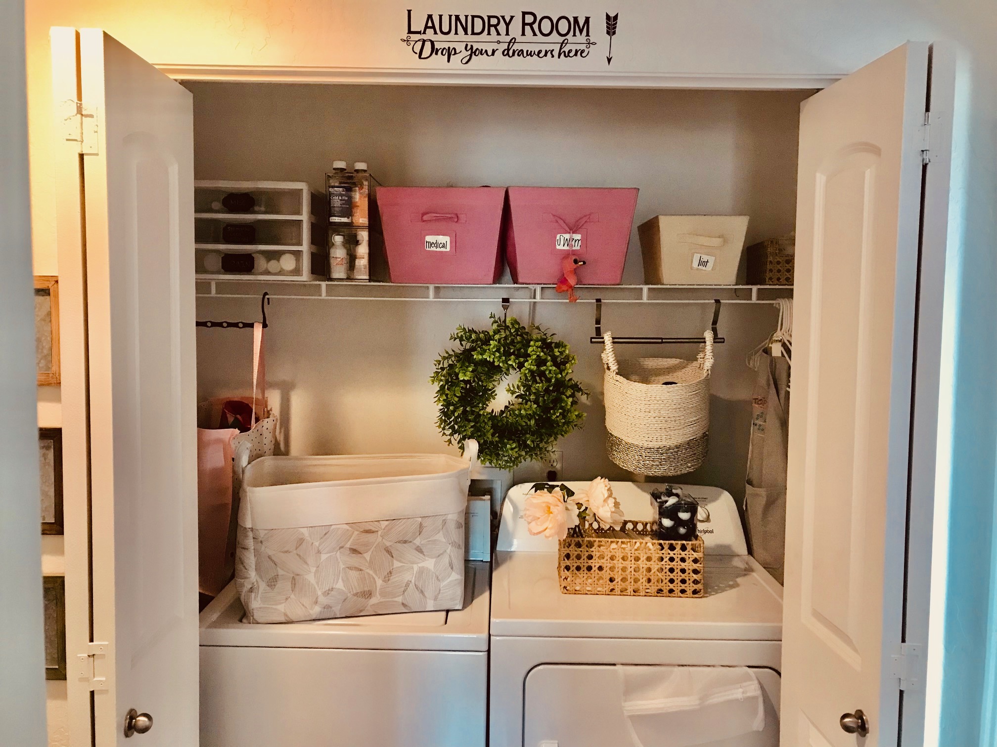 Laundry room with various bins and banskets. A wreath in the center and various containers for laundry supplies.