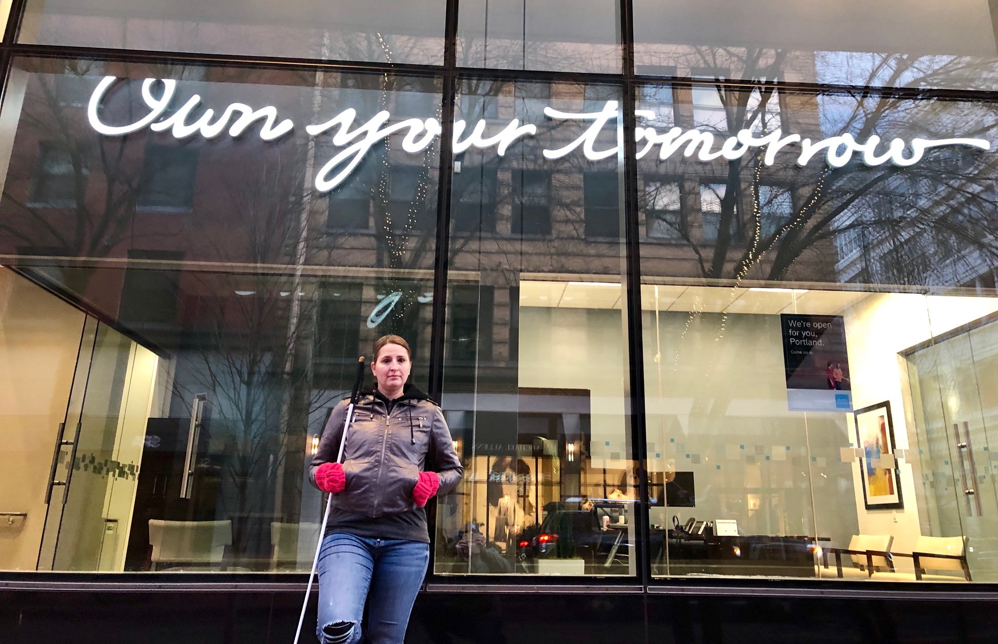 Deja with short dark hair and bright lipstick with a serious look.